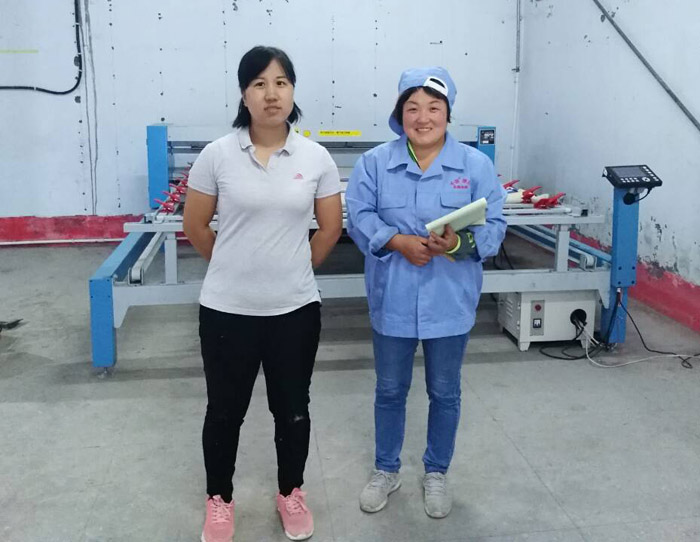 潘老板老婆和工人在电脑绗缝机前的合影